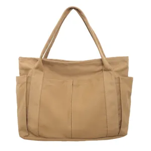 Canvas tote bag detail view, casual khaki handbag with front pockets, large capacity style.