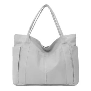 Grey canvas tote bag detail, multi-pocket design, daily casual shoulder bag accessory.