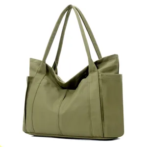 Detail view of the army green canvas tote bag featuring durable handles and side pocket storage.