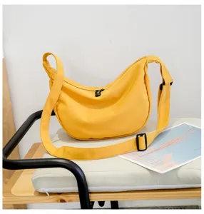 Yellow nylon crescent shoulder bag, casual dumpling crossbody bag with adjustable strap and smooth zipper.