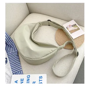 Vue détaillée du sac bandoulière en toile de nylon vert clair, sac besace décontracté.