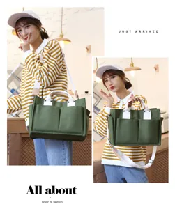 Green canvas tote bag with large capacity, multiple pockets, and comfortable shoulder straps.