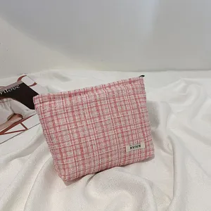 Detailed view of pink tweed cosmetic bag with soft texture and chic pattern for storage.