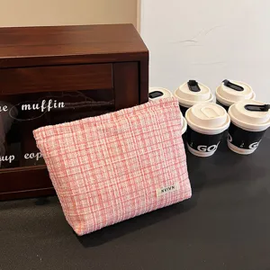 Detail view of pink tweed cosmetic bag, high-end storage pouch for makeup and toiletries.