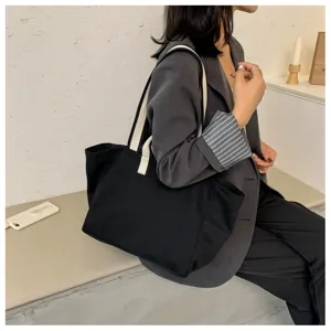 Minimalist black canvas tote bag for women, large capacity shoulder bag for daily commuting.