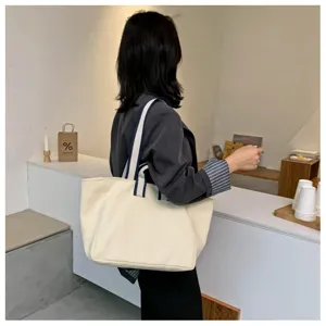 Minimalist large capacity canvas shoulder bag for women, commuter handbag with striped straps.
