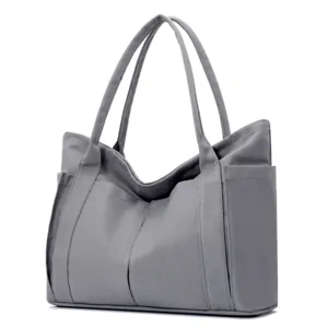 Grey canvas tote bag detail view, showing durable fabric texture and practical side pockets.
