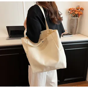 Canvas tote bag detail shot showing shoulder strap and side pocket design in neutral beige.