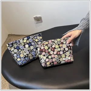 Close-up detail of compact floral cosmetic makeup pouch, stylish fabric storage bag for daily use.