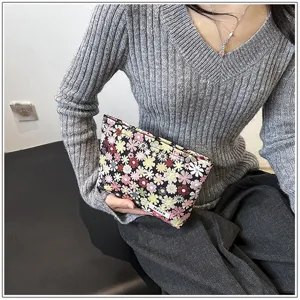 Detailed shot of a stylish floral cosmetic pouch being held by a model, perfect for daily use.