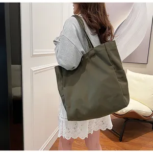 Detailed view of large capacity dark green canvas shoulder tote bag, durable daily commuting bag.