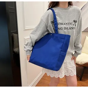 Blue canvas tote bag lifestyle scene showing shoulder carry detail and large capacity design.