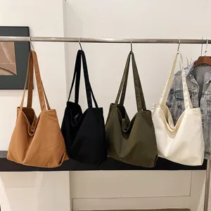 Detailed scene view of multiple canvas tote bags hanging neatly on a metal rack for everyday use.