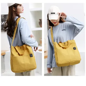 Detail view of the yellow canvas tote bag with dual handles and front pockets for daily use.