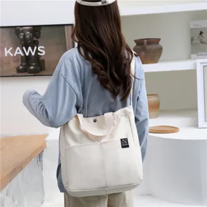 Casual canvas tote bag for women, minimalist shoulder shopping bag with front pocket.