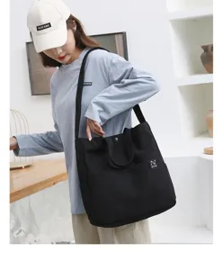 Black canvas tote shoulder bag for women, casual daily shopping bag with pockets.