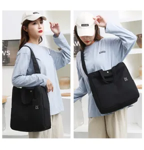 Black canvas tote bag for women, casual shoulder handbag with front pocket for daily use.