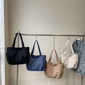 Minimalist solid color shoulder tote bag with multiple pockets for daily casual use.