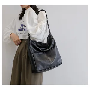 Detailed view of the black PU leather shoulder bag highlighting stitching design.