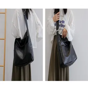 Detailed view of women black PU leather shoulder bag worn by model, casual daily style.