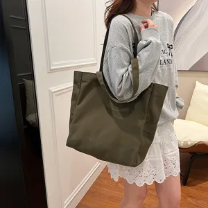 Detail view of a solid dark green canvas tote bag with large capacity and shoulder straps.