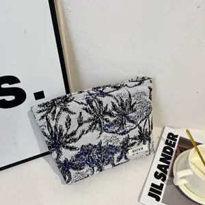 Vue détaillée de la trousse de toilette tissée avec motif d'arbres pour le rangement quotidien.