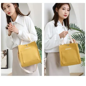 Detailed view of a stylish yellow canvas tote bag for women, featuring dual handles and strap.