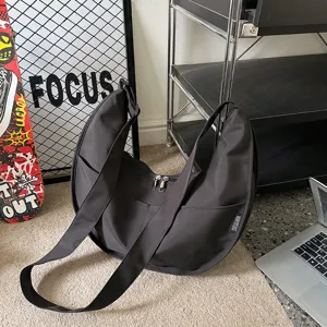 Black hobo dumpling shoulder bag for women, casual streetwear crossbody handbag with wide strap.