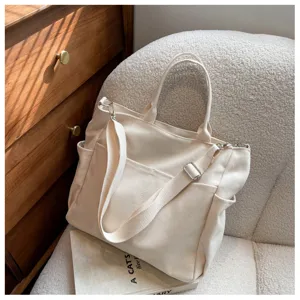 Casual canvas tote bag with multiple pockets, top handle and adjustable strap for women.