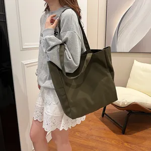 Detail view of the dark green canvas tote bag worn by model, showcasing large capacity.
