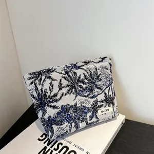 Trousse de maquillage en tissu à motif de palmiers bleu et blanc, sac de rangement portable.