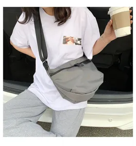 Grey nylon crossbody bag detail, casual minimalist shoulder bag design for women wear.
