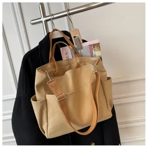 Canvas tote bag with multi pockets and shoulder strap for casual daily use and travel.
