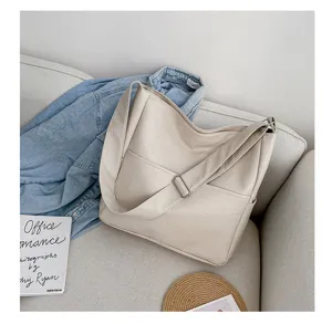 Detail shot of the beige PU leather shoulder bag featuring clean stitching and front pocket design.