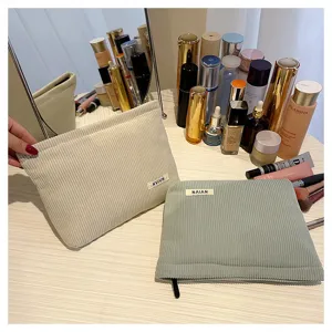 Corduroy cosmetic bag detail showing soft texture, solid color design, and neat woven label.