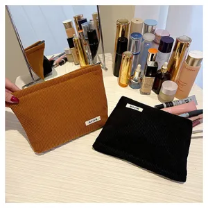 Close-up detail of corduroy cosmetic pouch in solid color, showing fabric texture and zipper.