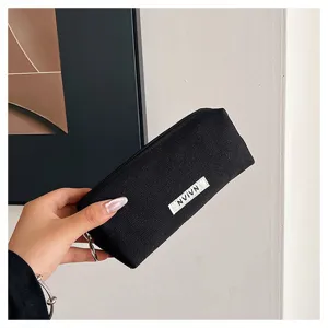 Black canvas pencil case detail view, minimalist style stationery pouch with zipper.