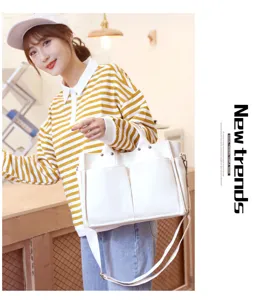 Detailed view of white canvas shoulder bag with multiple pockets, casual daily use style.