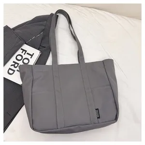 Casual gray canvas tote bag for women, large capacity commuter shoulder bag detail.