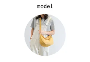 Vue détaillée du sac bandoulière en nylon élégant porté par le modèle, look décontracté.