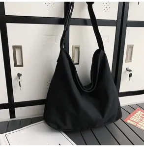 Detailansicht einer schwarzen Canvas Umhängetasche, lässiges Design mit viel Stauraum.