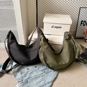 Detailed view of casual nylon dumpling shoulder bag, solid crescent shape with smooth zipper.