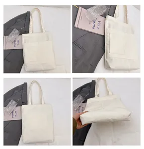 White canvas tote bag detail view, casual shoulder bag with front pocket and zipper closure.