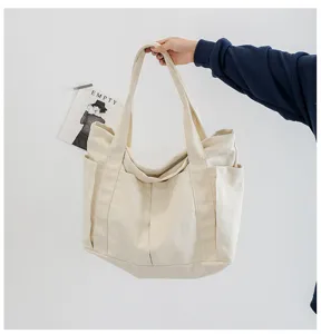 Detail view of casual canvas tote bag with side pockets, spacious interior and double handles.