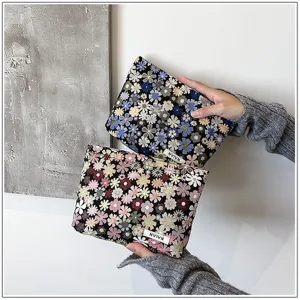 Floral cosmetic bag detail view, portable makeup storage pouch with daisy pattern.