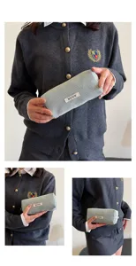 Gedetailleerde close-up van het vintage corduroy etui in de hand met zachte textuur.