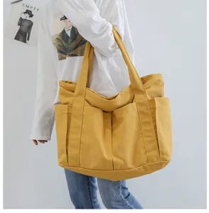 Detailed showcase of the yellow canvas tote bag showing its multiple exterior side pockets.