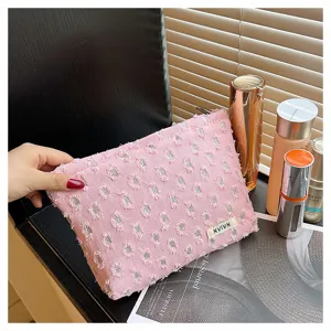 Pink frayed linen cosmetic pouch detail, portable travel storage and toiletry bag for daily use.