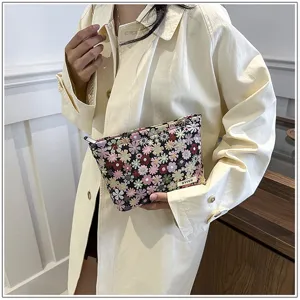 Detailed view of the portable floral cosmetic pouch with zipper closure, ideal for travel.