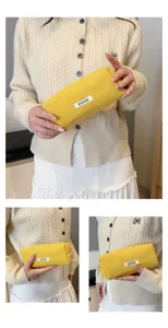 Gedetailleerd overzicht van het gele corduroy etui met een zachte textuur en wit label.